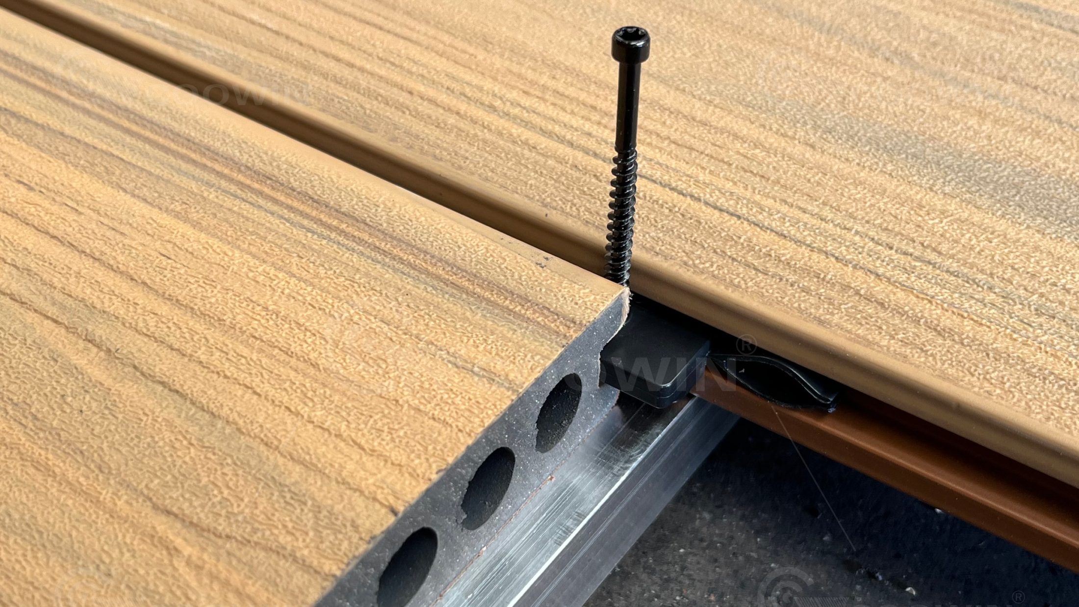 Composite deck board with hidden plastic fastener clip